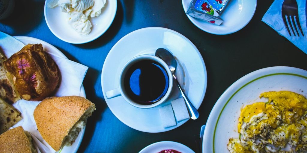cooked foods on plate and black coffee