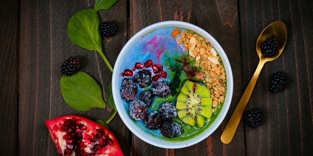 mixed fruits on bowl with blueberry on top