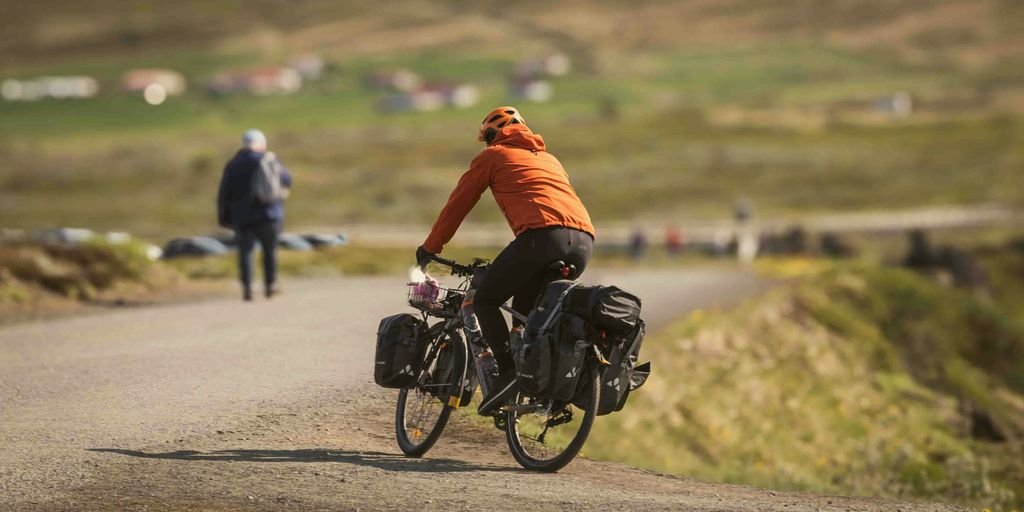 a man riding a bike down a dirt road