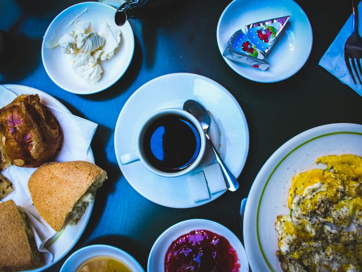 cooked foods on plate and black coffee